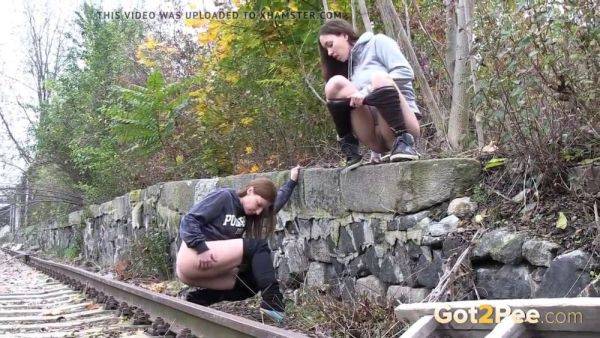 Watch these kinky girls get soaked in pee while getting frisky on the railway - sexu.com on poweredporn.com